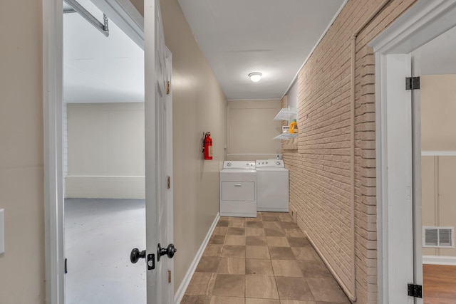 909 Woods Lake Dr, Madison, TN 37115 - laundry room with brick wall and washing machine and clothes dryer