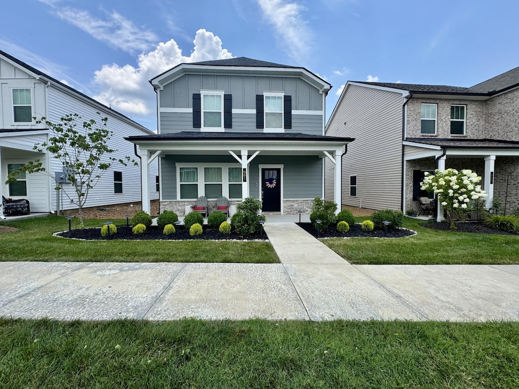 661 Taylor Bend Rd, Columbia, TN 38401 - view of front of house with board and batten siding, a front yard, covered porch, and stone siding