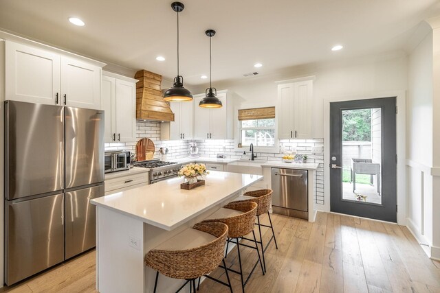 1446 Littleton Ranch Rd, Castalian Springs, TN 37031 - kitchen featuring stainless steel appliances, premium range hood, a kitchen bar, a kitchen island, and light countertops