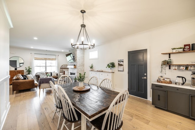 1446 Littleton Ranch Rd, Castalian Springs, TN 37031 - dining space featuring light wood-style floors, a large fireplace, a chandelier, recessed lighting, and crown molding