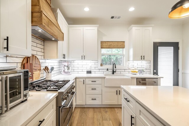 1446 Littleton Ranch Rd, Castalian Springs, TN 37031 - kitchen featuring custom range hood, appliances with stainless steel finishes, white cabinets, light countertops, and recessed lighting