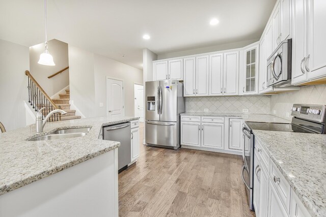835 Meadowcrest Way, Lebanon, TN 37090 - kitchen with appliances with stainless steel finishes, white cabinetry, light wood finished floors, decorative backsplash, and light stone countertops