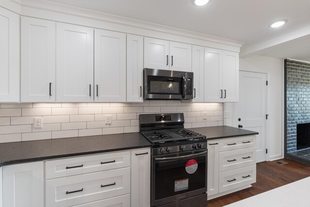 2210 Garners Creek Rd, Dickson, TN 37055 - kitchen with stainless steel appliances, dark countertops, dark wood-style flooring, tasteful backsplash, and white cabinetry