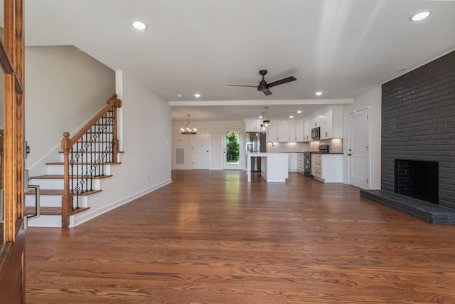 2210 Garners Creek Rd, Dickson, TN 37055 - unfurnished living room with a ceiling fan, dark wood-style floors, a chandelier, a fireplace, and recessed lighting