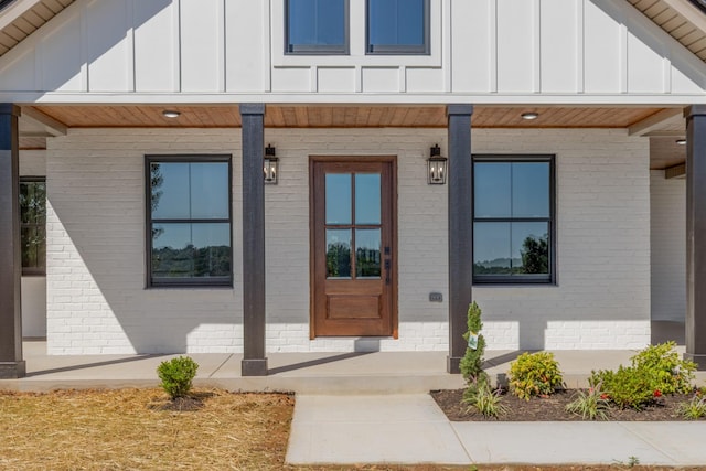 2210 Garners Creek Rd, Dickson, TN 37055 - doorway to property featuring board and batten siding, brick siding, and covered porch