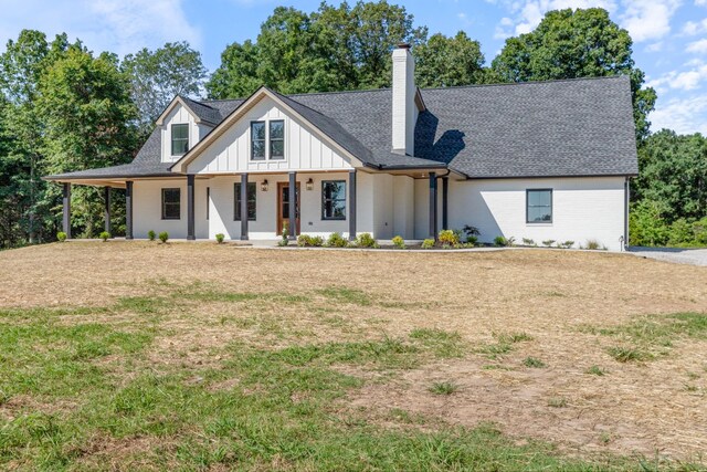 2210 Garners Creek Rd, Dickson, TN 37055 - modern inspired farmhouse with a porch, a front lawn, a chimney, board and batten siding, and a shingled roof