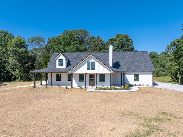 2210 Garners Creek Rd, Dickson, TN 37055 - modern farmhouse with a chimney, a porch, a shingled roof, board and batten siding, and view of scattered trees
