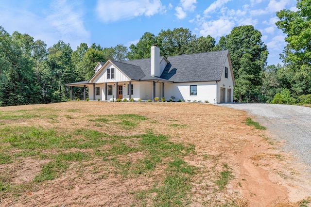 2210 Garners Creek Rd, Dickson, TN 37055 - view of front facade featuring driveway, a porch, an attached garage, a chimney, and roof with shingles