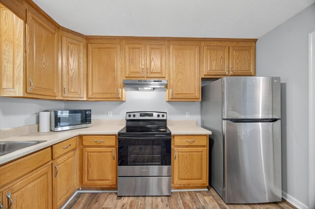 7 Summerfield Dr, Fayetteville, TN 37334 - kitchen with appliances with stainless steel finishes, under cabinet range hood, light countertops, and light wood-type flooring