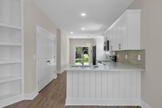 1104 Bridge St, Columbia, TN 38401 - kitchen featuring appliances with stainless steel finishes, light countertops, wood finished floors, built in features, and white cabinets