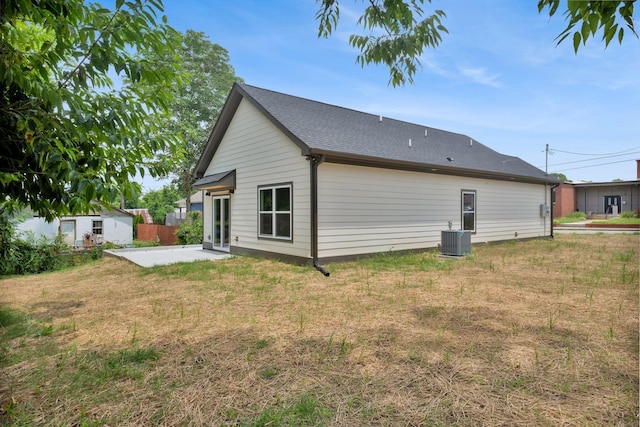 1104 Bridge St, Columbia, TN 38401 - rear view of house featuring a patio area, an outdoor structure, a lawn, and a shingled roof