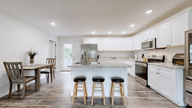 341 Holly Grove Rd, Lewisburg, TN 37091 - kitchen with stainless steel appliances, an island with sink, white cabinets, recessed lighting, and a breakfast bar