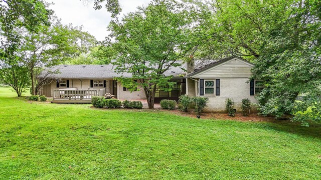 4623 Lebanon Rd, Murfreesboro, TN 37129 - back of property featuring a yard, brick siding, a wooden deck, and a sunroom