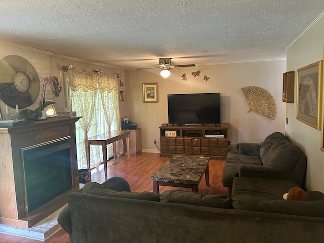 217 Millcreek Dr, Loretto, TN 38469 - living room featuring ornamental molding, a textured ceiling, wood finished floors, ceiling fan, and a fireplace with raised hearth