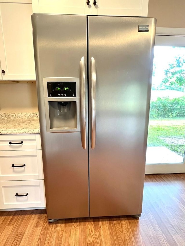 210 Roney Dr, Hopkinsville, KY 42240 - kitchen view of stainless steel refrigerator with ice dispenser, light wood-style floors, white cabinets, and light stone countertops