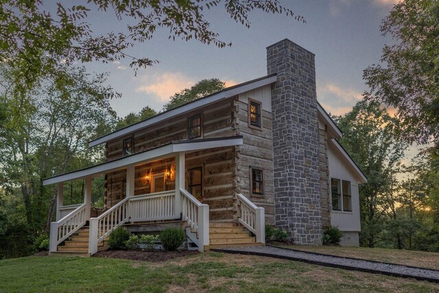 8014 Shoals Branch Rd, Primm Springs, TN 38476 - view of front facade featuring covered porch, a chimney, a yard, log exterior, and stairs