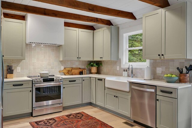 8014 Shoals Branch Rd, Primm Springs, TN 38476 - kitchen with appliances with stainless steel finishes, range hood, light wood finished floors, beam ceiling, and light countertops