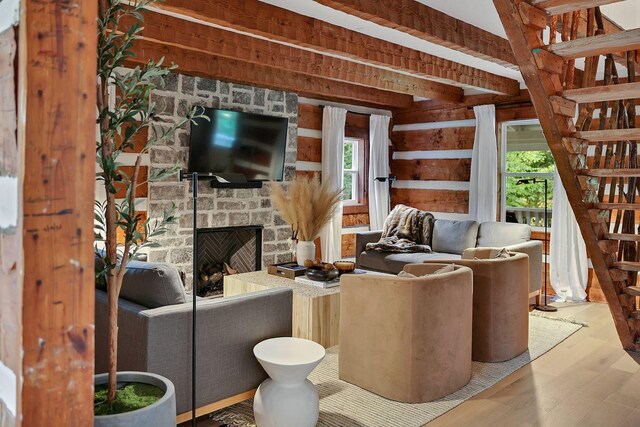 8014 Shoals Branch Rd, Primm Springs, TN 38476 - living room with stairs, wood finished floors, a stone fireplace, and wood walls