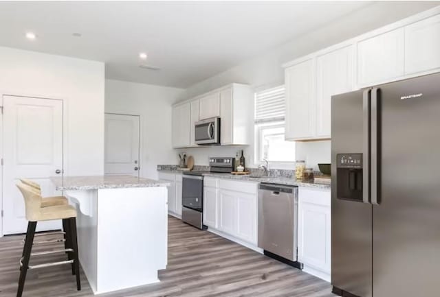 3380 Tucker Trce, Columbia, TN 38401 - kitchen with stainless steel appliances, a center island, white cabinetry, wood finished floors, and recessed lighting