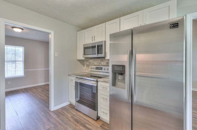 212 Towbridge Dr, Murfreesboro, TN 37129 - kitchen with appliances with stainless steel finishes, wood finished floors, white cabinetry, backsplash, and light stone countertops