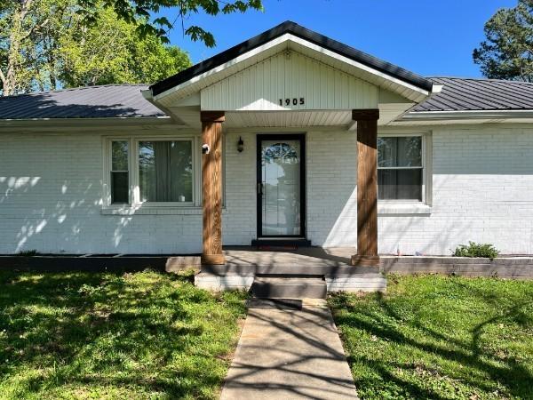 1905 Highland Ave, Columbia, TN 38401 - property entrance with brick siding, a porch, and a lawn