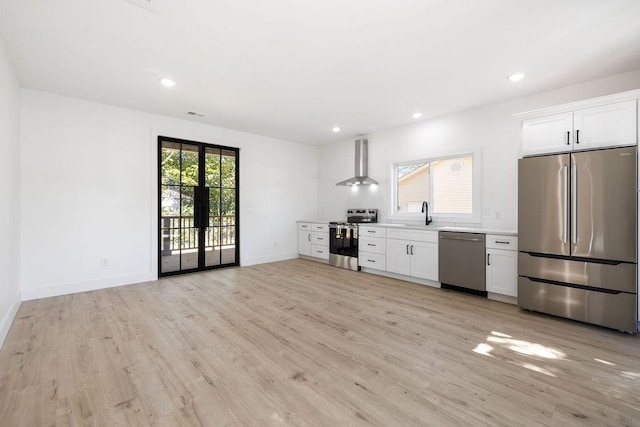 1905 Highland Ave, Columbia, TN 38401 - kitchen with stainless steel appliances, wall chimney exhaust hood, light countertops, light wood-style floors, and white cabinetry