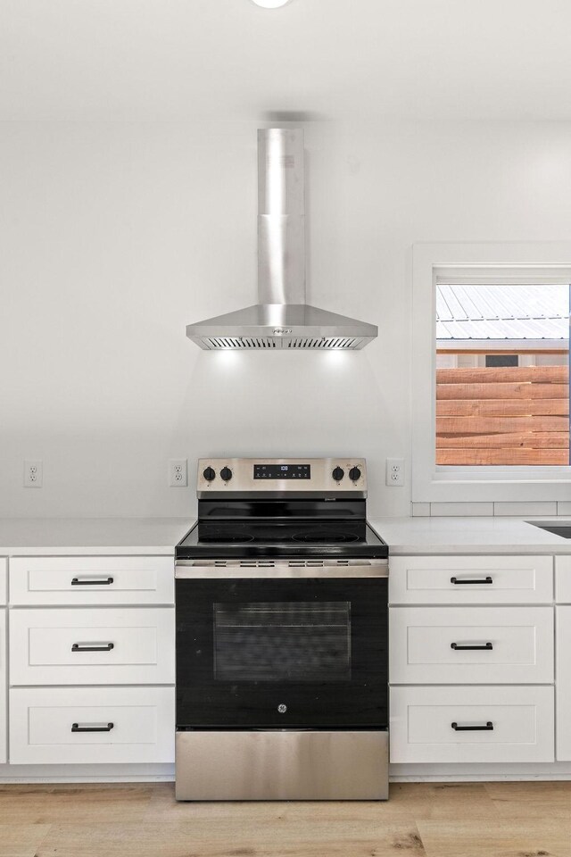 1905 Highland Ave, Columbia, TN 38401 - kitchen with stainless steel electric range oven, wall chimney exhaust hood, light countertops, and white cabinets