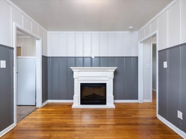 1905 Highland Ave, Columbia, TN 38401 - unfurnished living room featuring a decorative wall, wood finished floors, and a glass covered fireplace