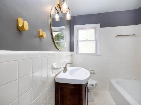 1905 Highland Ave, Columbia, TN 38401 - bathroom featuring vanity, a tub, tile walls, a wainscoted wall, and a shower