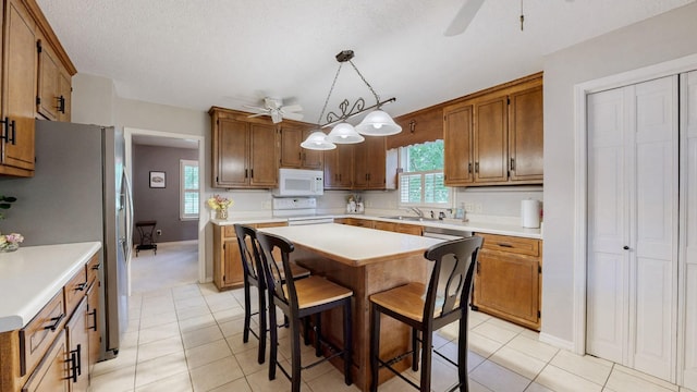 1335 Chippendale Cir, Columbia, TN 38401 - kitchen with white appliances, a ceiling fan, light countertops, plenty of natural light, and a textured ceiling