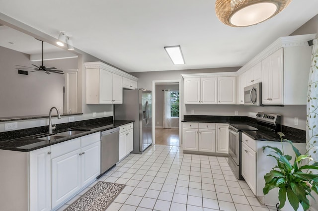 2910 Churchill Ln, Thompsons Station, TN 37179 - kitchen featuring appliances with stainless steel finishes, white cabinetry, light tile patterned floors, a ceiling fan, and a peninsula
