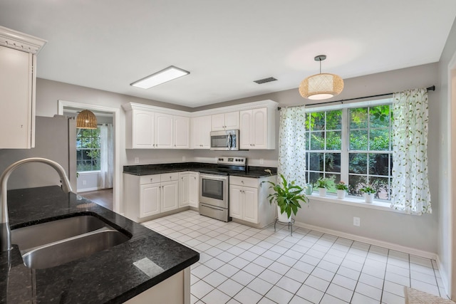 2910 Churchill Ln, Thompsons Station, TN 37179 - kitchen with appliances with stainless steel finishes, healthy amount of natural light, light tile patterned floors, and white cabinets