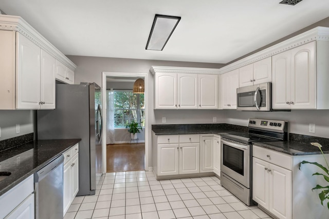 2910 Churchill Ln, Thompsons Station, TN 37179 - kitchen featuring appliances with stainless steel finishes, light tile patterned floors, dark stone counters, and white cabinetry