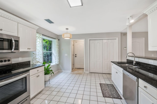 2910 Churchill Ln, Thompsons Station, TN 37179 - kitchen with appliances with stainless steel finishes, light tile patterned floors, white cabinetry, decorative light fixtures, and dark stone counters