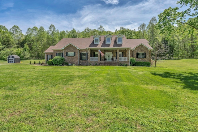 2600 Little Bartons Creek Rd, Cumberland Furnace, TN 37051 - new england style home with covered porch, a shed, a front yard, and brick siding