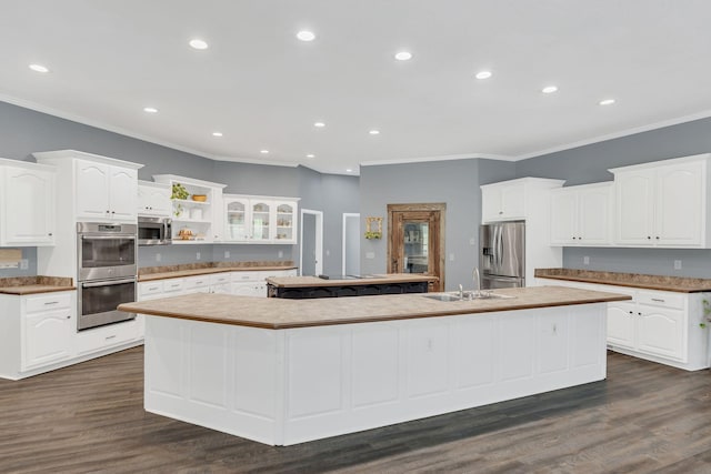 2600 Little Bartons Creek Rd, Cumberland Furnace, TN 37051 - kitchen featuring appliances with stainless steel finishes, a large island, ornamental molding, white cabinetry, and dark wood-type flooring