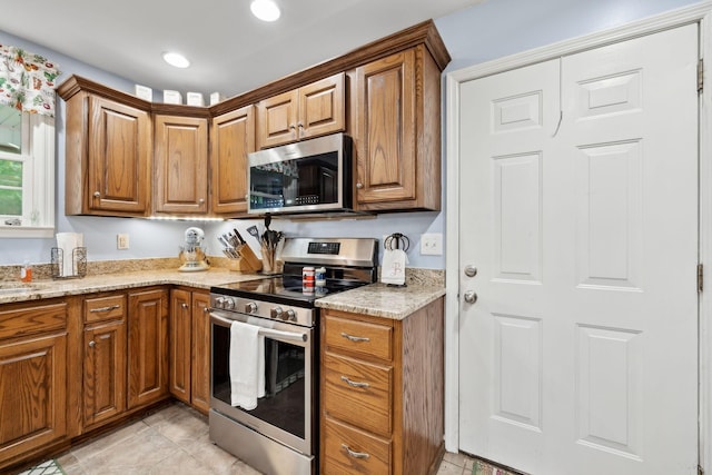 1550 Beech Bottom Rd, Watertown, TN 37184 - kitchen featuring appliances with stainless steel finishes, brown cabinetry, light stone countertops, and recessed lighting