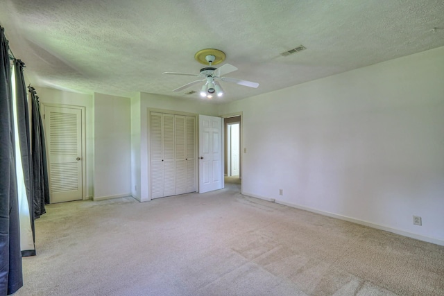 2010 Hartland Rd, Franklin, TN 37069 - unfurnished bedroom with light colored carpet, a textured ceiling, ceiling fan, and multiple closets