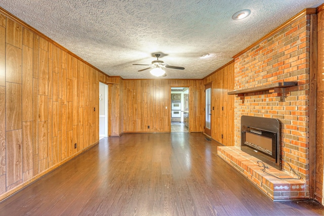 2010 Hartland Rd, Franklin, TN 37069 - unfurnished living room featuring crown molding, wood finished floors, a ceiling fan, a brick fireplace, and wooden walls