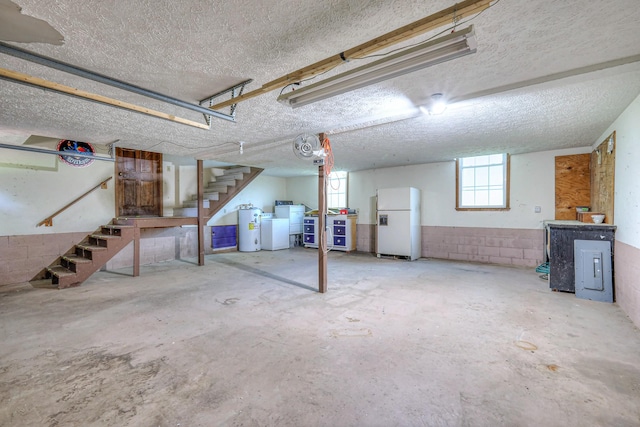 2010 Hartland Rd, Franklin, TN 37069 - basement featuring freestanding refrigerator, stairs, electric water heater, independent washer and dryer, and a textured ceiling
