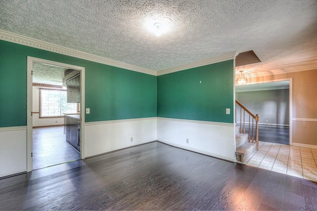2010 Hartland Rd, Franklin, TN 37069 - unfurnished room with wood finished floors, stairway, ornamental molding, and a textured ceiling