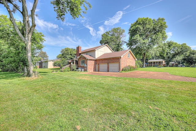 2010 Hartland Rd, Franklin, TN 37069 - view of property exterior featuring brick siding, a garage, a chimney, a lawn, and driveway