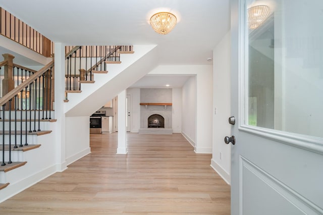 1026 Carthage Hwy, Lebanon, TN 37087 - foyer featuring light wood-style flooring, stairway, a fireplace with raised hearth, and a chandelier
