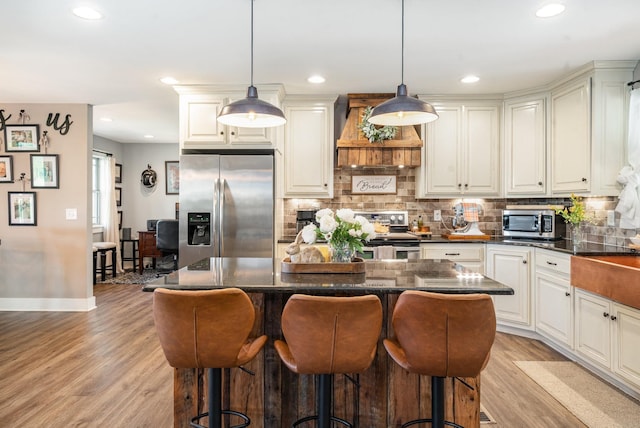 398 Beasleys Bend Rd, Lebanon, TN 37087 - kitchen featuring appliances with stainless steel finishes, extractor fan, light wood-style floors, a kitchen bar, and tasteful backsplash