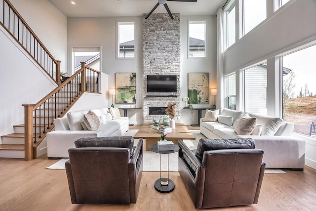 1224 Ben Forkum Dr, Lebanon, TN 37087 - living room with stairway, a fireplace, light wood finished floors, a high ceiling, and ceiling fan