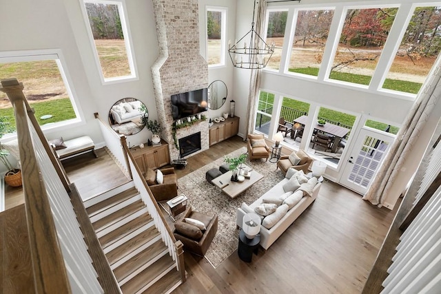 1224 Ben Forkum Dr, Lebanon, TN 37087 - living room with a high ceiling, a fireplace, wood finished floors, and a chandelier