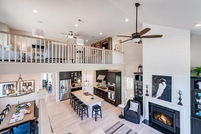 1107 Willow Springs Dr, Lebanon, TN 37087 - living room featuring ceiling fan, a fireplace, high vaulted ceiling, light wood-type flooring, and a chandelier