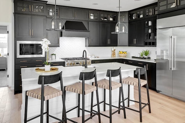 1107 Willow Springs Dr, Lebanon, TN 37087 - kitchen with built in appliances, dark cabinets, custom exhaust hood, and light countertops