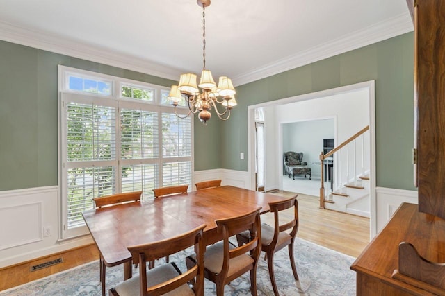 7125 Locksley Ln, Fairview, TN 37062 - dining room featuring a wainscoted wall, a decorative wall, a chandelier, healthy amount of natural light, and crown molding