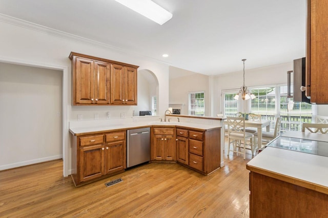 7125 Locksley Ln, Fairview, TN 37062 - kitchen with stainless steel dishwasher, brown cabinetry, a peninsula, light wood finished floors, and crown molding